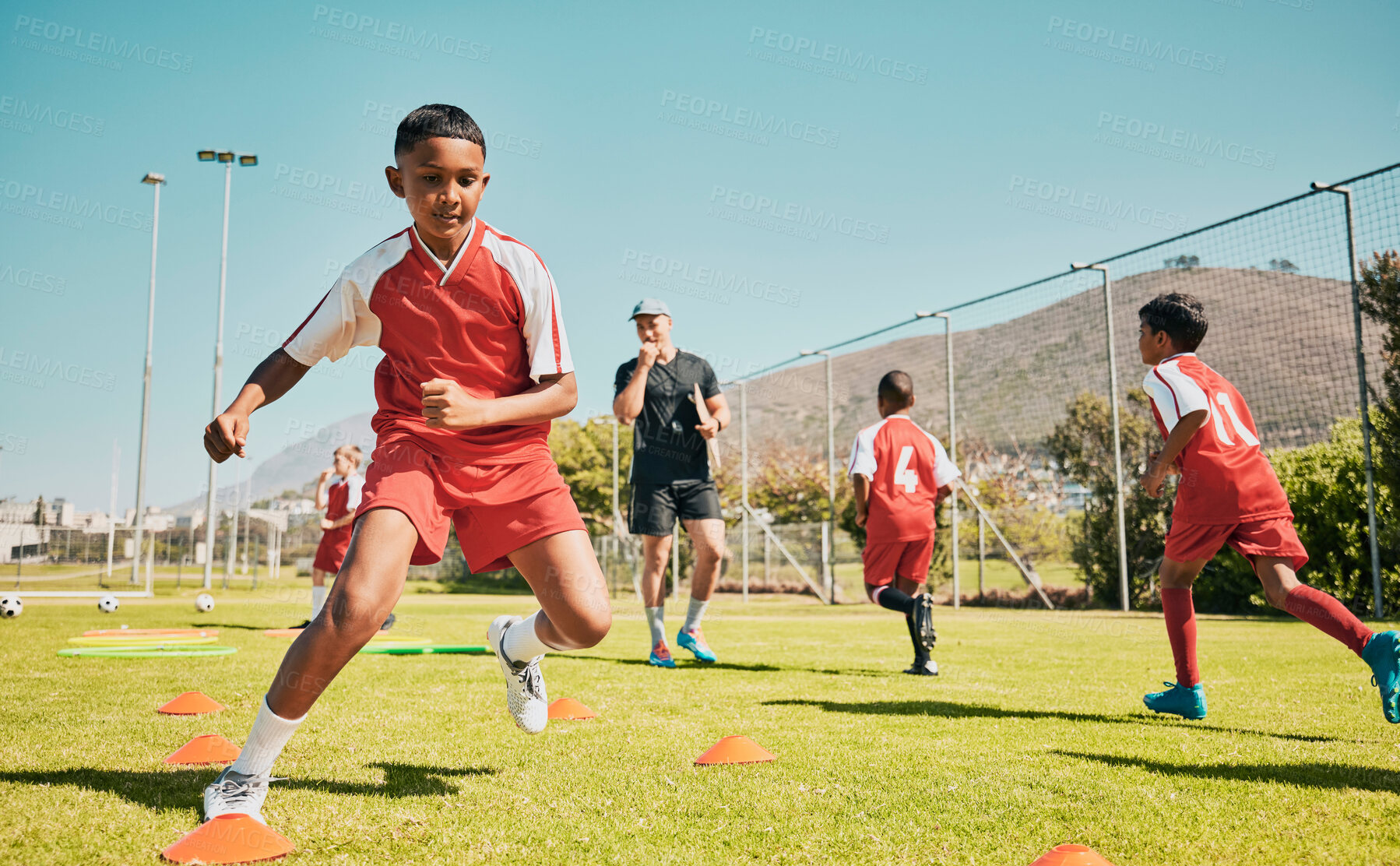 Buy stock photo Soccer, children and training or practice for sports competition or game on soccer field for fitness, exercise and energy. Football player, cone and sport with kids coach outdoor for team practice