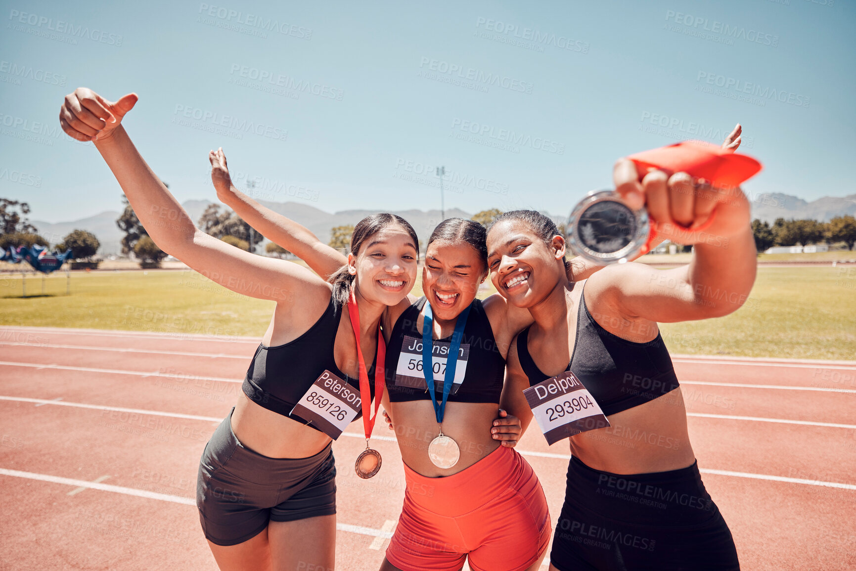 Buy stock photo Medal, champion and women at a stadium for sports, running and celebration of winning marathon. Diversity, winner and athlete team with an award for achievement in a sport competition with smile