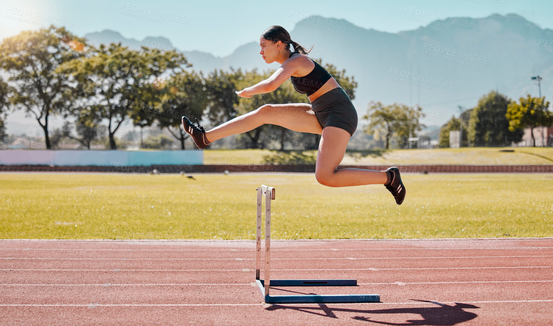 Buy stock photo Jump hurdle, athlete and woman in competition, on track or running to win, for wellness and healthy. Fitness, female and girl training, exercise and workout for health, cardio and jumping for victory