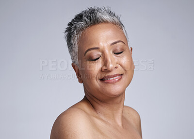 Buy stock photo Mature woman, face and skincare glow on gray studio background with makeup cosmetics, dermatology wellness and mockup. Smile, happy or Indian beauty model with healthy facial collagen and self care