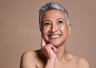 Buy stock photo Face, skincare and senior woman thinking about cosmetics in studio isolated on a brown background. Wellness, vision or happy mature female model from India with beauty or makeup idea for healthy skin