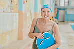 Senior woman, smile and swimming lesson, pool and workout, sport and training with happiness indoor. Portrait, happy or elderly female at swimming pool for swim class, learning or exercise with board