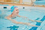 Swimming, physiotherapy and exercise with a senior woman in water for rehabilitation or recovery. Fitness, pool and health with a mature female being active during a swim in the gym for wellness