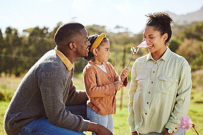 Buy stock photo Happy family, countryside fun and child with flower tickle mom's nose, play or enjoy outdoor quality time together. Love, nature freedom and spring peace for kid girl, parents or bonding black family