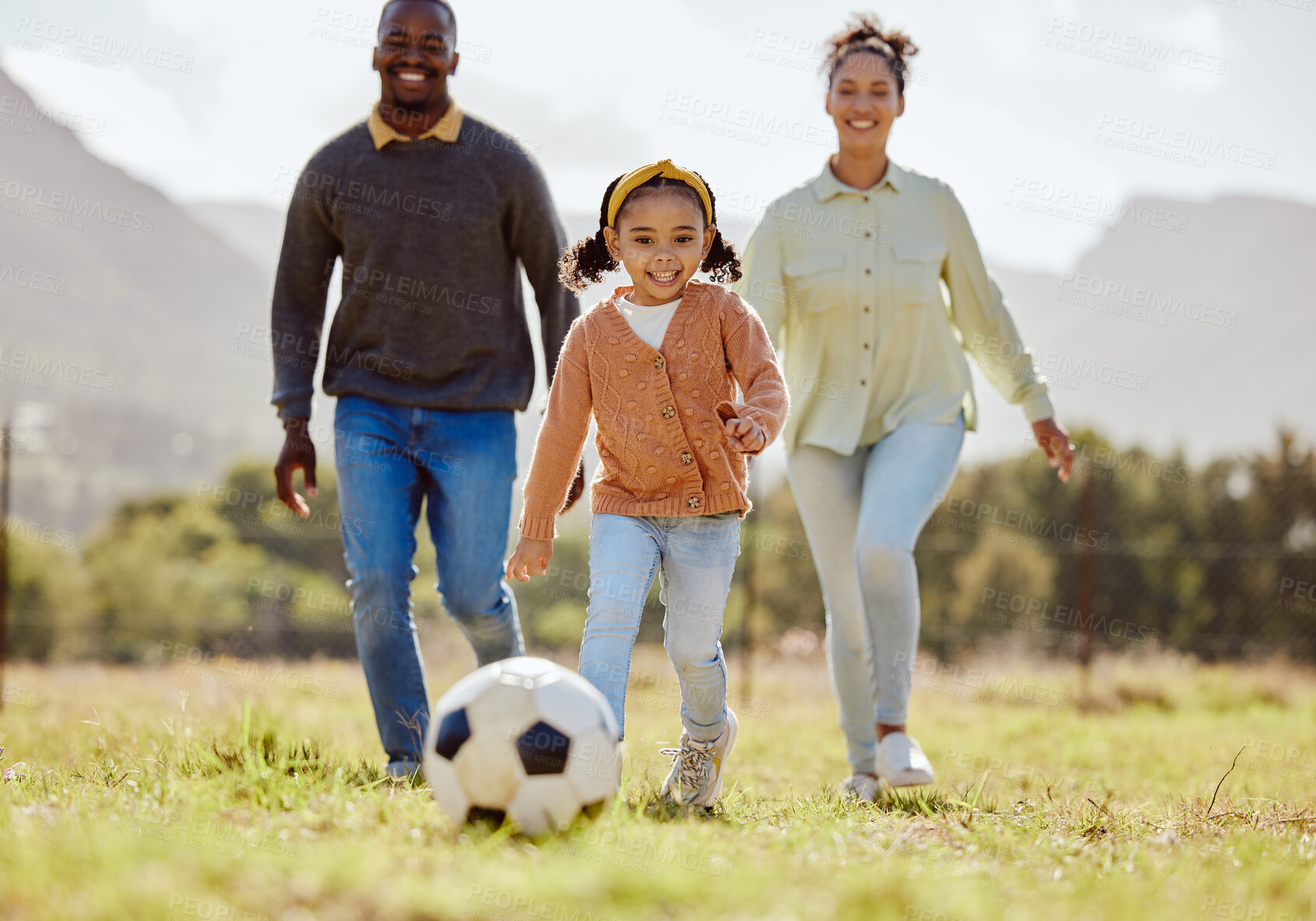 Buy stock photo Happy family, soccer ball and playing on the grass in nature for fun, bonding and active exercise in the outdoors. Mother, father and child enjoying quality family time together with ball on a field