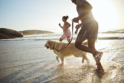 Buy stock photo Running, dog and beach with a black couple and pet in the water while on holiday or vacation by the coast. Sand, travel and animal with a man, woman and canine in the ocean or sea during summer