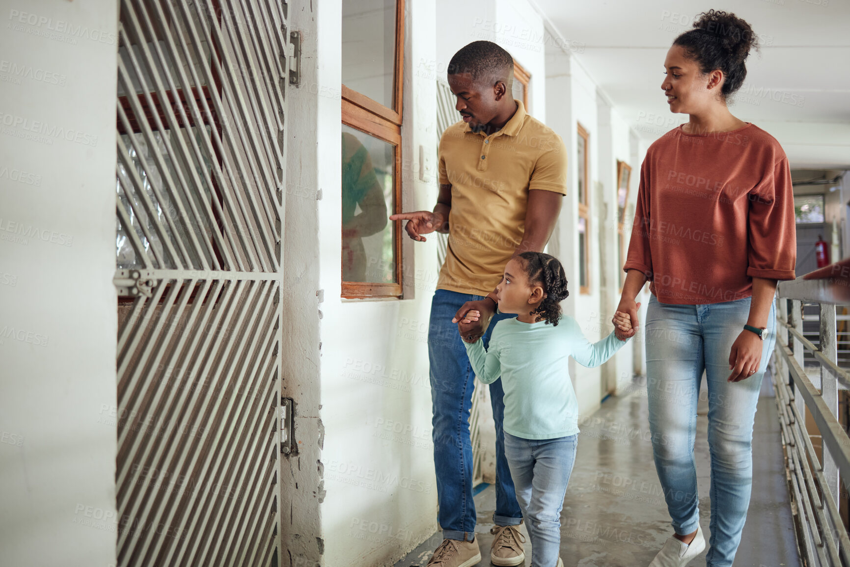 Buy stock photo Black family, animal shelter and planning adoption with mother, father and child walking together inside vet building for charity or volunteer work. Man, woman and girl together at pet ngo center