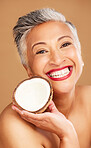 Senior woman, skincare and coconut in studio for beauty, health and wellness in happy cosmetic portrait. Healthy, elderly black woman and fruit by face for cosmetics, skin and happiness by background