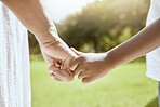 Park, family and parent holding hands with child bonding together enjoying nature and outdoors. Summer, love and hands of young kid with adult bonding, carefree on weekend, holiday and vacation