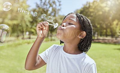 Buy stock photo Park, child and black girl blowing bubbles enjoying fun time alone outdoors, joy and childhood development. Happy, freedom and kid learning and playing with soap bubble toy or wand and relax on grass