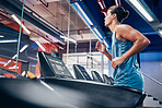 Fitness, man and running on treadmill for workout, exercise or cardio training for endurance at the gym. Active male runner in sports wellness having a run on stationary equipment at the health club