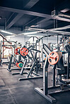 Gym, equipment and weights of fitness background for exercise, training or heavy workout for strength, muscle building and wellness. Empty health club of interior space and machines for exercising