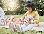 Mother, picnic and happy child in a interracial family with a smile, floor hug and happiness. Summer fun, laughing and love of mom and girl on a vacation feeling relax in a garden field outdoor park