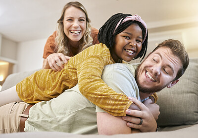 Buy stock photo Family, adoption and love with a mother, father and foster child together on living room couch for fun, happiness and bonding. Portrait, smile and trust of man, woman and girl share hug for sopport