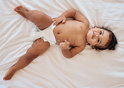 Buy stock photo Happy baby, smile and relax on bed in family home bedroom for diaper change, bedtime or healthy childcare. Child, happiness and body care in disposable nappy or kids portrait from above in nursery