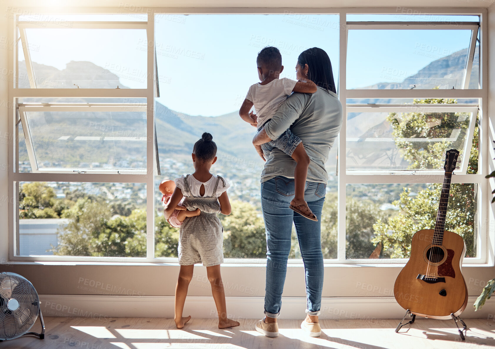 Buy stock photo Child, window and view with mother and brother while holding her doll at home. Little girl, woman and siblings with parent looking at while bonding and relaxing with mom in the family home with love