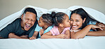 Black family, bed together and happy under blanket in home with love, care and bonding with kiss on cheek. Black woman, man and kids in bedroom in house for happy family moment, time or relax in home