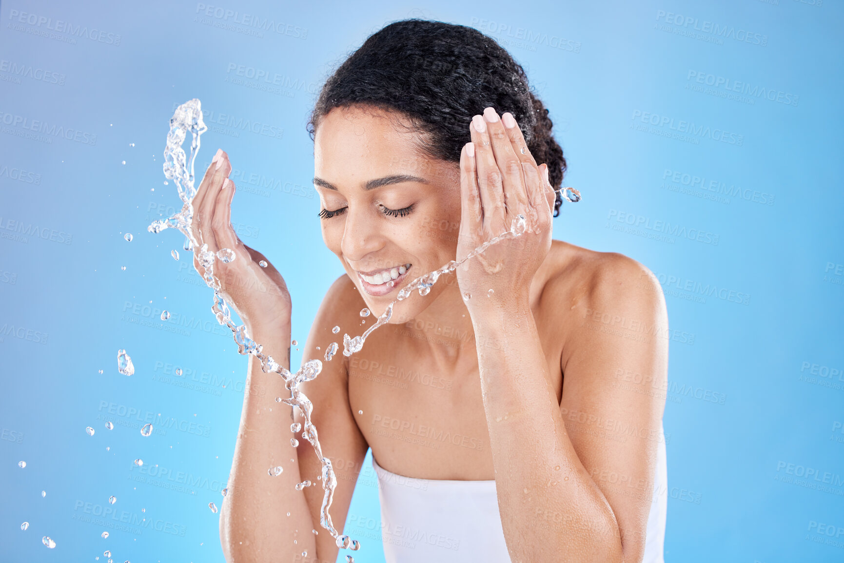 Buy stock photo Black woman, water splash for face cleaning, skincare wellness or luxury spa facial beauty in blue background studio. Skin, smile or happy girl model for water, shower or health cosmetics advertising