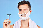 Man, razor and shaving with cream, happy and skincare while grooming beard, morning and cosmetic in blue studio background with mockup. Smile, clean and model cleaning facial hair for natural beauty