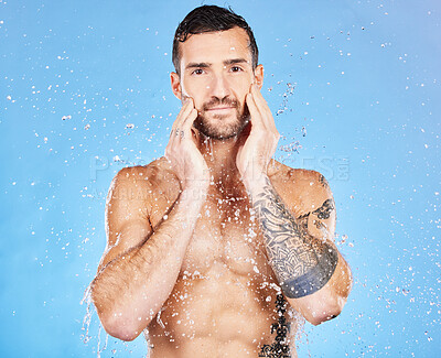 Buy stock photo Water, cleaning and man washing face for skincare, wellness and health of body against a blue studio background. Shower, happy and portrait of a model with care for grooming, hygiene and skin