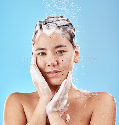 Buy stock photo Shower, shampoo and hair care, woman with soap and clean portrait for grooming and hygiene against blue studio background. Face, hands and wellness with washing hair and beauty with water droplets.