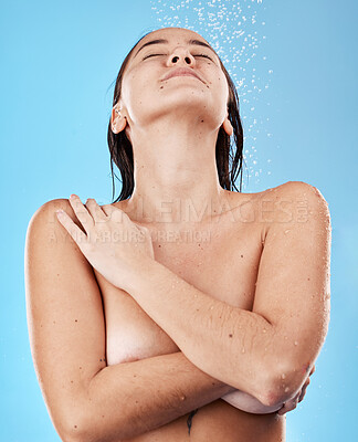 Buy stock photo Shower, body and woman in the nude with water for cleaning, grooming and hygiene against a blue studio background. Skin, wellness and happy Asian model with peace, calm and relax while showering