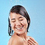 Shower, water and woman in a studio for skincare, cleaning or wellness with a self care mindset. Cosmetics, beauty and wet Asian model with a skin or body care routine isolated by a blue background.