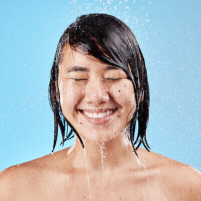 Buy stock photo Shower, water and woman with face, wellness and hygiene with wet splash, body care or on blue studio background. Fresh, young female and girl bathroom, skincare or cleaning for luxury, relax or smile