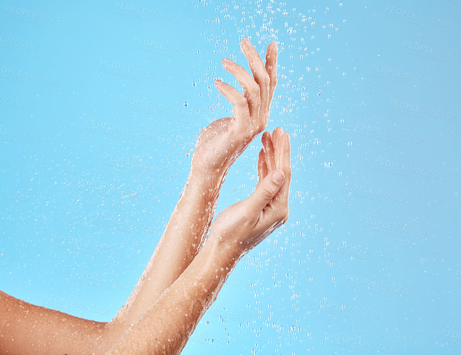 Buy stock photo Hand, water and cleansing for health, wellness and bodycare on a blue studio background. Hands, fingers and shower cleaning of body and arms for cleansing, hygiene and grooming flow 