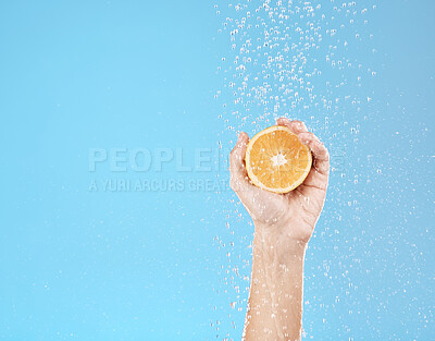 Buy stock photo Hand, orange and water with natural skincare for health, wellness and organic fruit on a blue studio background. Beauty, fresh and food for juicy vitamin c skin care treatment for dermatology