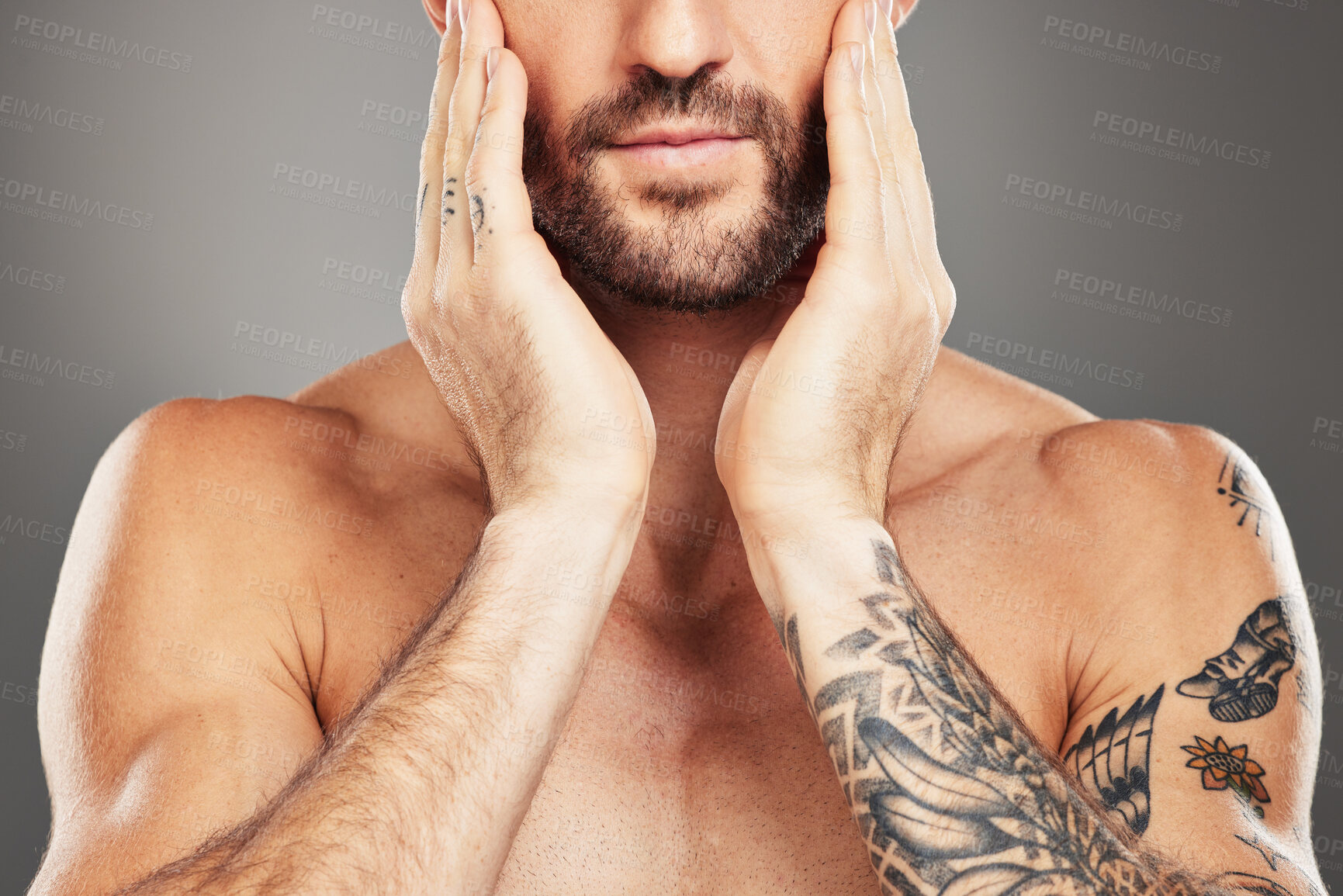 Buy stock photo Beauty, skincare and body with a man model in studio on a gray background with an arm tattoo for wellness. Health, luxury and skin with a male touching his face for cleaning or natural bodycare