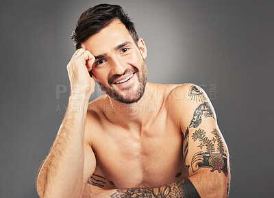 Buy stock photo Man, beauty and sexy with body, tattoo and happy portrait against grey studio background with mockup space. Male model, sexy and smile for self care, skincare and cosmetic wellness with clean face