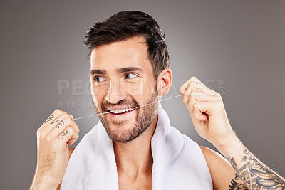 Teeth, dental floss and cleaning man in studio isolated on gray background. Oral care, dental health and happy male model from Australia tooth flossing for gum care, wellness or healthy mouth hygiene