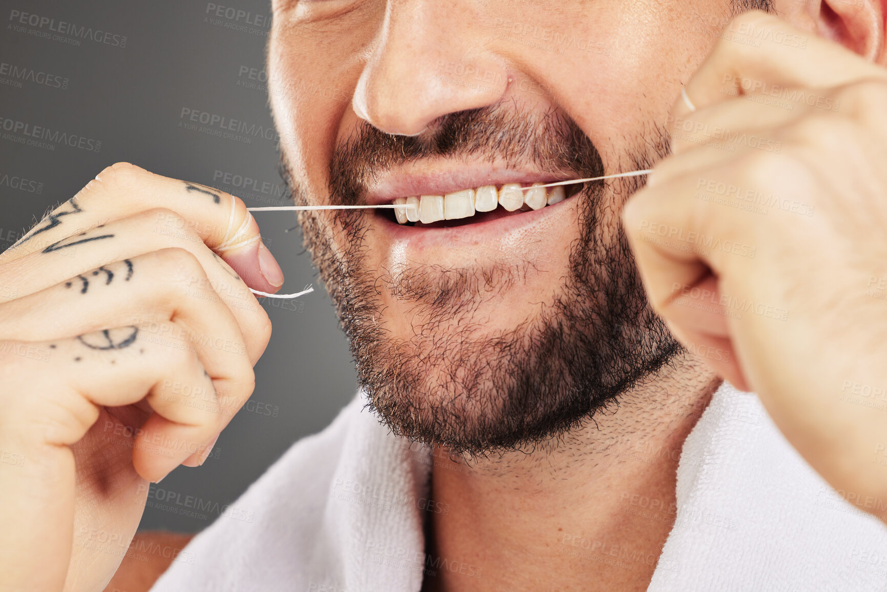 Buy stock photo Floss, dental hygiene and man cleaning teeth, for wellness and against grey studio background. Oral health, healthy male and thin filaments string for fresh breath, remove plaque and mouth healthcare