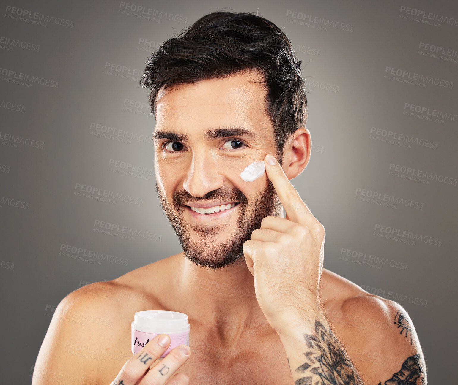 Buy stock photo Skincare, wellness and man with facial cream isolated on gray background in studio. Beauty, grooming and male apply lotion, beauty product and skincare products on face for body care and healthy skin