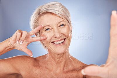 Buy stock photo Mature woman, peace sign or face selfie on studio background in wellness health success, dermatology progress or fun self love. Portrait, happy smile or skincare beauty model in cool hand gesture pov