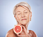 Mature woman, fruit and skincare, beauty and health for vitamin c anti aging, fresh skin care and body care on a grey studio background. Citrus, grapefruit and antioxidants for organic treatment