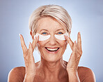 Face, skincare and old with woman eye patches on a blue studio background. Portrait, beauty and elderly female model from Canada with anti aging product, facial pads or collagen eye mask for wellness