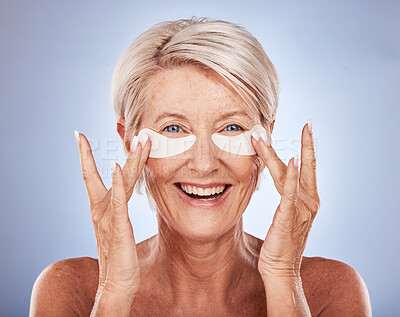 Buy stock photo Face, skincare and old with woman eye patches on a blue studio background. Portrait, beauty and elderly female model from Canada with anti aging product, facial pads or collagen eye mask for wellness