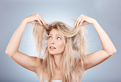 Buy stock photo Hair care, stress and woman sad about frizz, split ends and messy style against a grey studio background. Frustrated, unhappy and angry model with problem with her hair, frustration and worry
