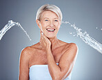 Water splash, skincare and senior woman with a smile for hydration, moisture and wellness of skin against grey studio background. Shower, beauty and happy elderly model with water drops and body care