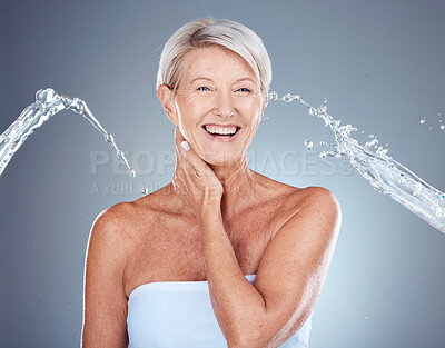 Buy stock photo Water splash, skincare and senior woman with a smile for hydration, moisture and wellness of skin against grey studio background. Shower, beauty and happy elderly model with water drops and body care