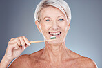 Dental, studio and senior woman brushing teeth on a gray background. Oral health, wellness and routine of elderly female from Canada holding toothbrush and cleaning teeth for hygiene and oral care

