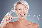 Skincare, water and portrait of old woman brushing teeth isolated on gray background in studio. Healthcare, wellness and senior female cleaning teeth with toothbrush for dental care and hygiene