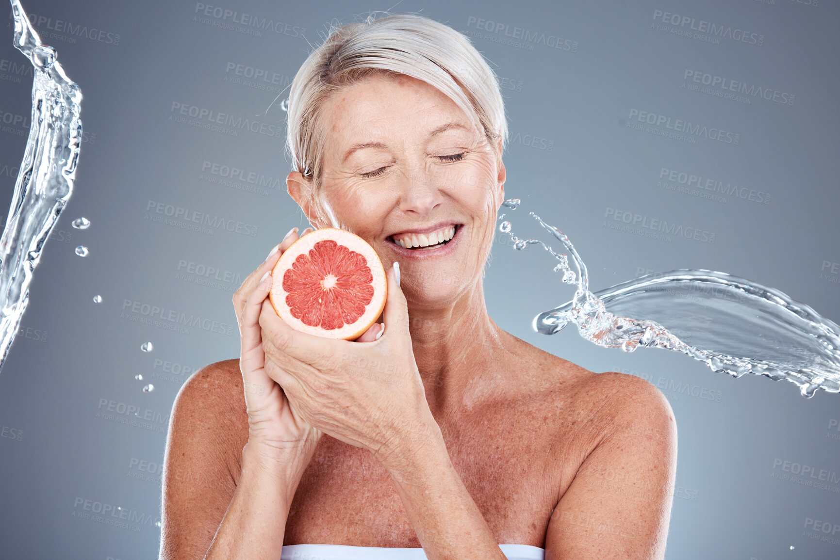 Buy stock photo Wellness, beauty and grapefruit woman with water splash for body care, skincare and health cosmetics marketing. Clean, happy and healthy senior model for cosmetic advertising on gray studio mockup.