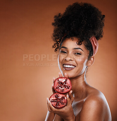 Buy stock photo Pomegranate, skincare and portrait of a black woman in studio with natural facial treatment. Health, wellness and young model with fruit for skin, face and beauty routine isolated by brown background