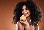 Black woman, fruit and natural beauty with an orange for skincare, health and glowing skin on a brown background. Cosmetic, vitamin c and citrus for organic facial treatment product and skin care