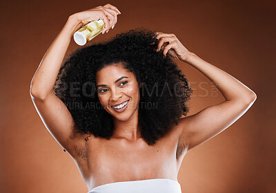 Buy stock photo Hair care, afro and spray with wellness, cosmetic and happy smile against a brown studio background with mockup. Happiness, health and care for curls with beauty, natural or  luxury cosmetics product