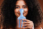 Black woman face, beauty and comb for hair care, beauty and afro with smile for happy smile in studio background. Portrait of African American female smiling for beauty hairstyle or salon treatment
