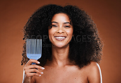 Buy stock photo Black woman, hair care and smile in portrait with comb, afro pick or beauty against brown backdrop. Happy African, model and woman with cosmetics, makeup or happiness for combing by studio background